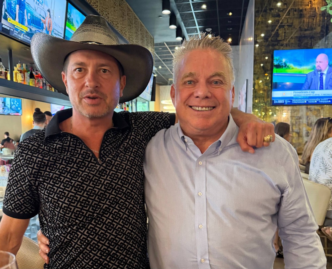 Billy Martin Jr. and Steve Bender smiling together, arm in arm, at a restaurant