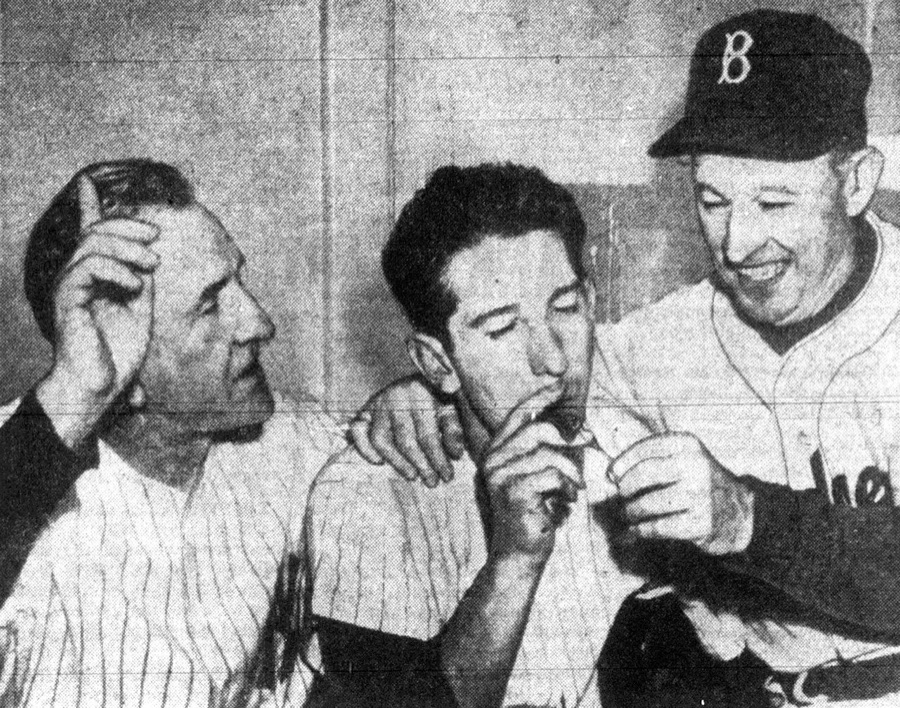 Dodgers manager Chuck Dressen lights a cigar for Billy Martin after the 1953 World Series
